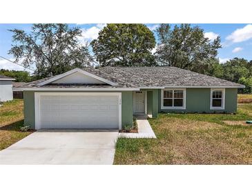 Charming home featuring a two-car garage, and a well-manicured lawn at 176 Pine Crse, Ocala, FL 34472