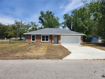 Charming one-story home featuring a two-car garage and manicured lawn on a sunny day at 3733 Se 137Th Street, Summerfield, FL 34491