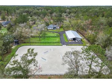 Expansive aerial view of horse training facility with riding arena, stables, pastures, and charming residence at 965 Nw 73Rd Ter, Ocala, FL 34482