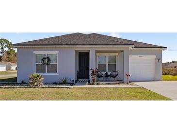 Charming one-story home with a gray exterior, a covered porch, and a two-car garage at 12803 Sw 73Rd Ter, Ocala, FL 34473