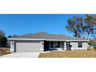 Charming single-story home with a well-manicured lawn and a classic gray color scheme at 7613 Sw 103Rd Loop, Ocala, FL 34476