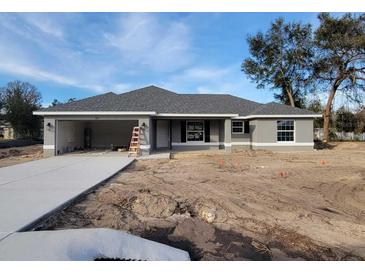 Newly constructed gray house with a two-car garage and a spacious front yard at 7613 Sw 103Rd Loop, Ocala, FL 34476