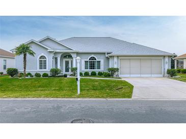 Charming single-story home with manicured lawn, arched windows, and a two-car garage at 5622 Nw 27Th Pl, Ocala, FL 34482