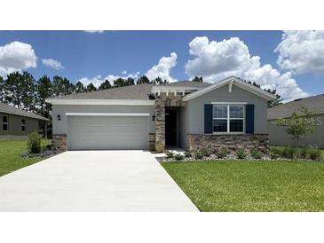 Charming one-story home featuring stone accents, a two-car garage, and a well-maintained lawn at 9295 Sw 60Th Court Rd, Ocala, FL 34476