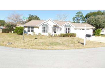 Charming single-story home with a well-manicured front yard and beautiful curb appeal on a sunny day at 10819 Sw 84Th Ter, Ocala, FL 34481