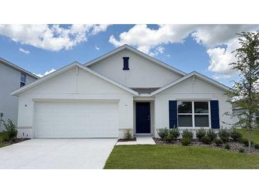 Charming single-story home boasts a well-manicured lawn, a two-car garage, and navy blue shutters and front door at 8465 Las Palmas Way, Wildwood, FL 34785