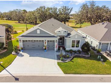 Exterior aerial view of a charming single-story home with well-manicured landscaping and a three-car garage at 4522 Shockoe Cir, The Villages, FL 32163