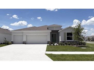 Charming single-story home boasts a well-manicured lawn and a two-car garage in a suburban neighborhood at 3092 Canopy Oak Blvd, Wildwood, FL 34785