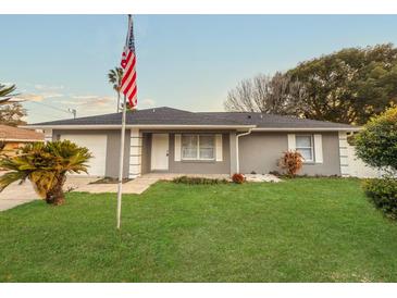 Charming single Gathering home featuring a lush lawn, attached garage, and welcoming front entrance at 7 Teak Loop Pl, Ocala, FL 34472