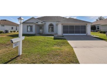 Single-story home with a two-car garage and landscaped lawn at 5520 Nw 26Th Ln, Ocala, FL 34482