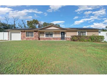 Charming single-story home with a well-maintained lawn and a mix of stone and stucco exterior finishes at 6931 Se 54Th St, Ocala, FL 34472