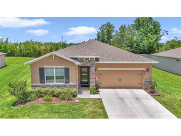 Beautiful single-story home featuring stone accents, manicured landscaping, and a two-car garage at 6365 Sw 88Th Loop, Ocala, FL 34476