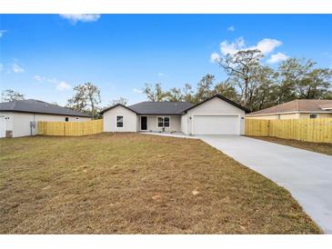 Charming single-story home featuring a neutral color scheme, attached two-car garage, and a well-manicured front yard at 5222 Nw 54Th Pl, Ocala, FL 34482