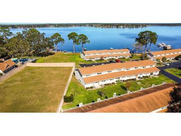 Beautiful aerial view of condo community along the lakefront with ample parking spaces at 11001 Se Sunset Harbor Rd # F45, Summerfield, FL 34491