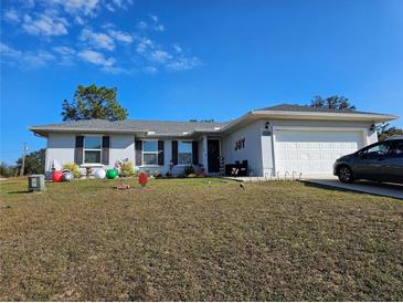 Single-story home with a landscaped yard and attached garage at 12495 Se 102Nd Ave, Belleview, FL 34420