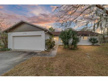 White single-story house with attached garage, and a well-maintained lawn at 3720 Se 24Th St, Ocala, FL 34471