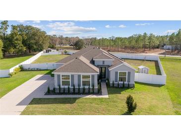 Inviting single-story home featuring manicured landscaping, modern colors, and a well-maintained lawn at 4812 Se 37Th St, Ocala, FL 34480