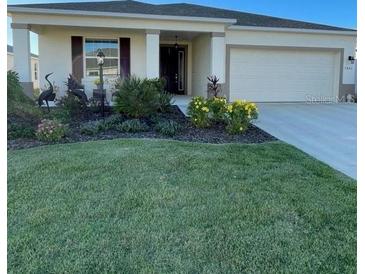 Single-story home with landscaped yard and two-car garage at 7682 Sw 89Th Ct, Ocala, FL 34481