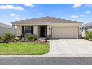 Charming single-story home featuring a well-manicured lawn and an attached two-car garage at 7682 Sw 89Th Ct, Ocala, FL 34481