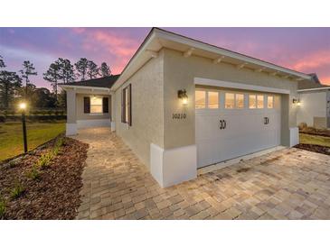 Two-story house with a two-car garage and a landscaped yard at 10210 Sw 99Th Ln, Ocala, FL 34481