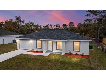 Newly constructed home with gray roof, white exterior, and landscaping at 14977 Sw 21St Pl, Ocala, FL 34481