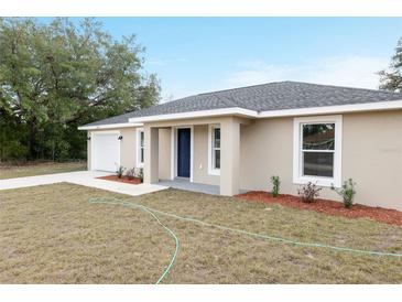 Charming single-story home with a well-maintained lawn, attached garage, and a welcoming front entrance at 14977 Sw 21St Pl, Ocala, FL 34481