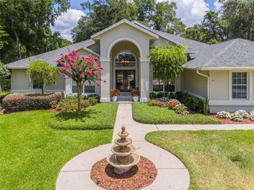 Beautiful home exterior featuring a fountain and manicured landscaping at 2215 Se Spring Hill Ct, Ocala, FL 34471