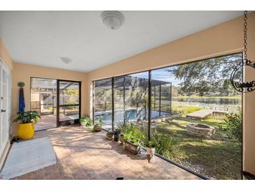 Bright screened porch overlooking a pool and lake at 37352 Turner Dr, Umatilla, FL 32784