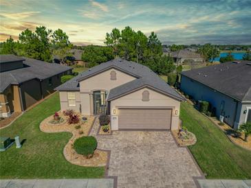 Beautifully landscaped home featuring a brick driveway, two-car garage, and a well-maintained lawn at 10129 Sw 77Th Loop, Ocala, FL 34481