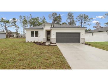 Charming single-story home featuring a well-manicured lawn and a modern two-car garage at 13143 Sw 67Th Ave, Ocala, FL 34473