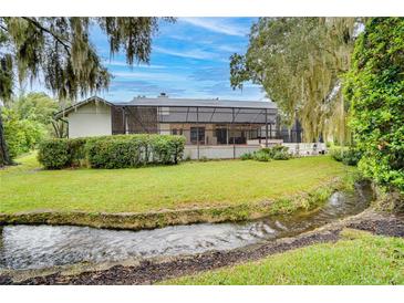 Charming home with a screened patio, lush lawn, and a peaceful creek at 2263 Se Laurel Run Dr, Ocala, FL 34471