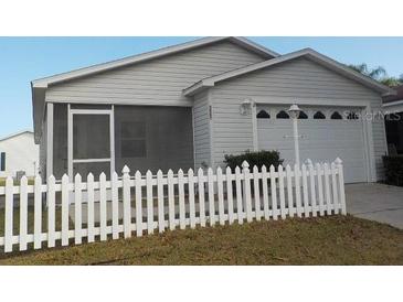 Cute house with white picket fence and a two-car garage at 321 Katherine Pl, The Villages, FL 32162