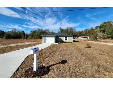Newly constructed home with attached garage and a neat lawn at 4698 Sw Zinnia, Dunnellon, FL 34431