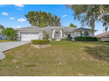 Single-story home with a two-car garage and manicured lawn at 5425 Sw 85Th Ln, Ocala, FL 34476