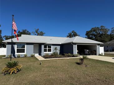 Gray house with white trim, two-car garage, and landscaped yard at 6671 Se 108Th St, Belleview, FL 34420