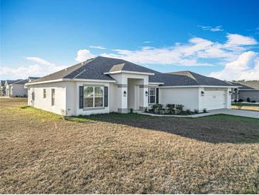 Single-story home with gray roof and landscaping at 9125 Se 47 Court Rd, Ocala, FL 34480