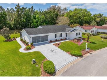 Single-story home with landscaped yard, driveway, and screened porch at 17380 Se 98Th Cir, Summerfield, FL 34491