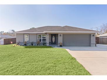 Newly built home with gray exterior, 2-car garage, and well-manicured lawn at 20 Fir Dr, Ocala, FL 34472