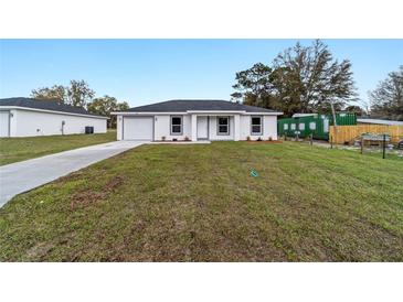 Charming single-story home featuring a well-maintained front yard, attached garage and neutral color palette at 2397 Sw 143 Ct, Ocala, FL 34481