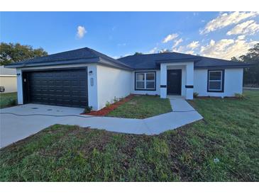 Charming single-story home with a black garage door and well-maintained front yard at 262 Locust Rd, Ocala, FL 34472