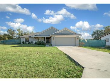 Single-story home with gray siding, attached garage, and a well-manicured lawn at 38 Spring Trce, Ocala, FL 34472