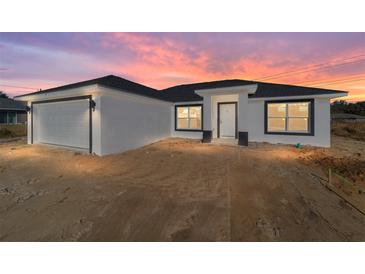 New construction home showcasing a modern exterior with a two-car garage at 55 Locust Loop Cir, Ocala, FL 34472