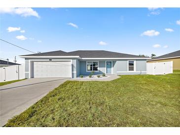 Newly constructed home with a light blue exterior, white garage door, and landscaped front yard at 7 Hemlock Radial, Ocala, FL 34472