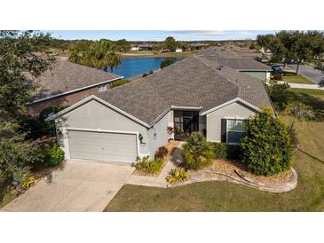 Single-story home with a gray roof and attached garage, situated on a landscaped lot at 9211 Sw 66Th Loop, Ocala, FL 34481