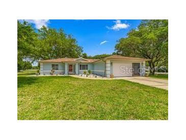 Ranch-style home with a carport and well-manicured lawn at 10557 Sw 62Nd Ct, Ocala, FL 34476