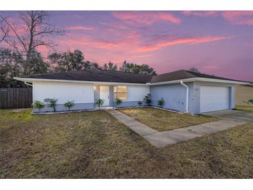 Newly renovated single-story home with a landscaped lawn and attached garage at 15154 Sw 38Th Cir, Ocala, FL 34473