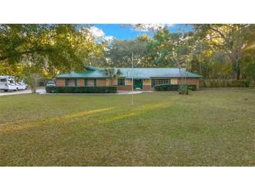 Single-story house with green roof, large yard, and ample parking at 1981 Se 54Th Ter, Ocala, FL 34480