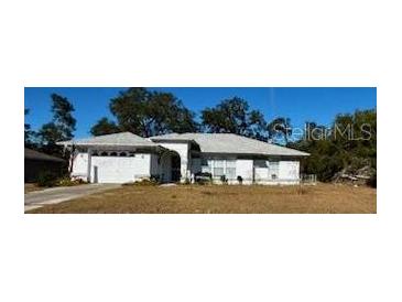 Single-story house with a light-colored exterior and a grassy front yard at 2849 Sw 140 Pl, Ocala, FL 34473