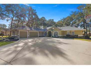 House exterior with three-car garage and circular driveway at 5224 Se 44Th Cir, Ocala, FL 34480