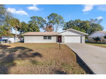 Ranch style home with a large yard and driveway at 562 Silver Course Loop, Ocala, FL 34472